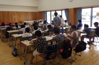 夏休みの宿題を持ち寄って静かに学習中。指導員が見守ります。